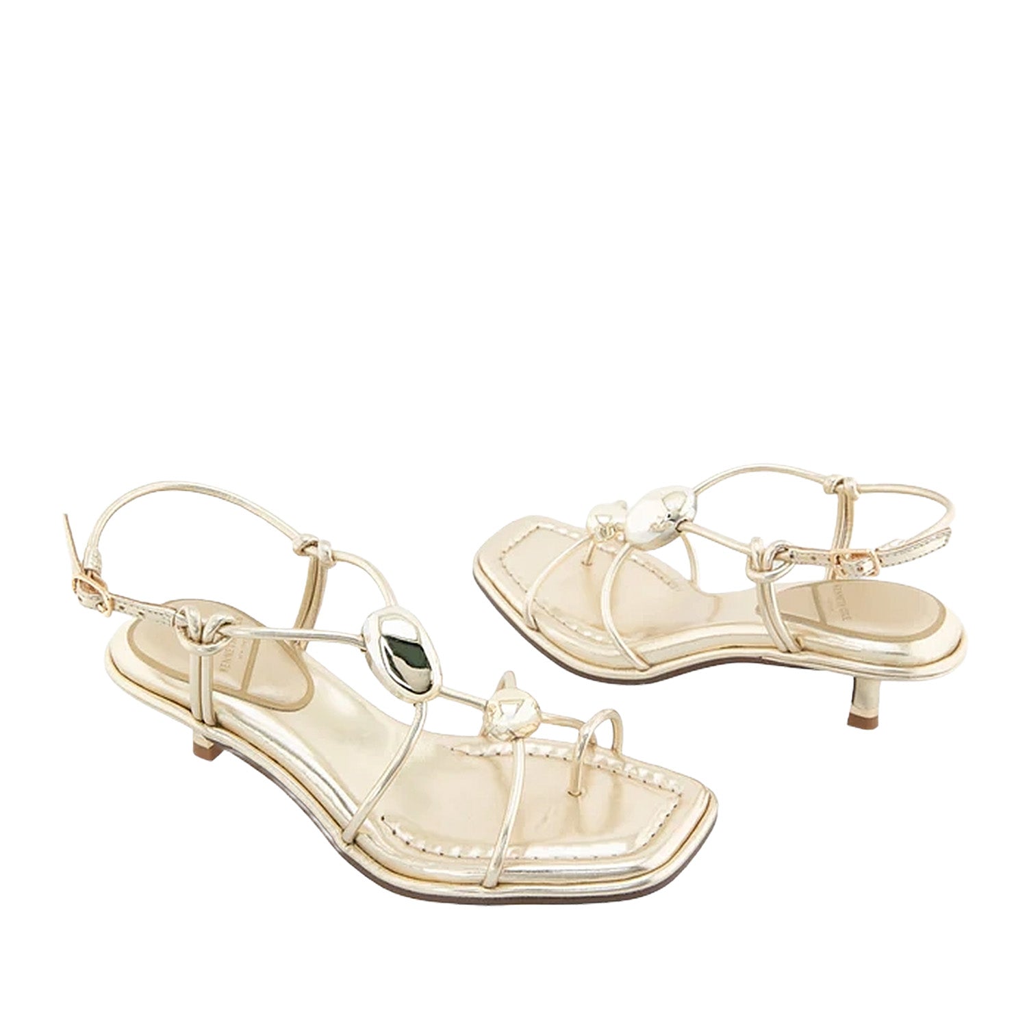 Gold metallic strappy sandal with decorative hardware, a toe-ring, and kitten heel.