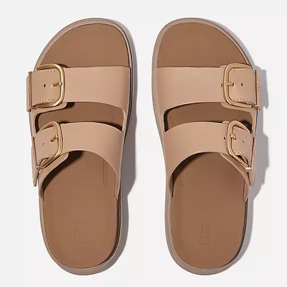 Light tan brown leather double strap slide sandal with large gold buckle details on straps. 